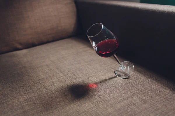 Vino rosso versato su un divano grigio . — Foto Stock