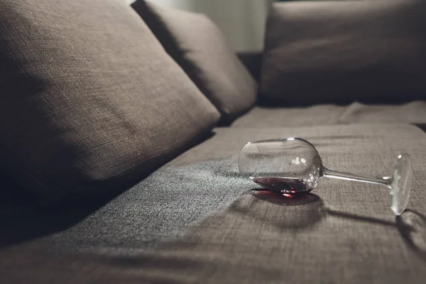 Rødvin spildt på en grå sofa sofa . — Stock-foto © vershinin.photo  #237728096
