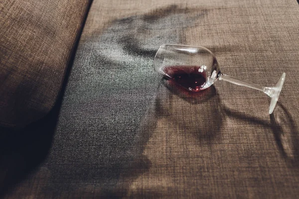 Vino rosso versato su un divano grigio . — Foto Stock