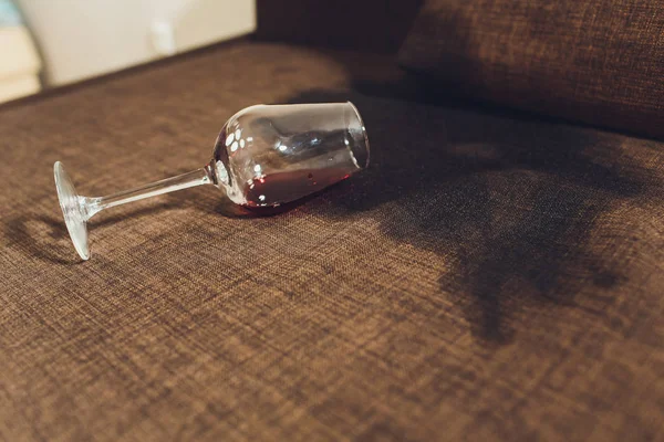 Red wine spilled on a grey couch sofa. — Stock Photo, Image