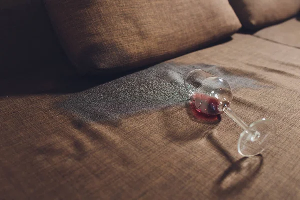 Red wine spilled on a grey couch sofa. — Stock Photo, Image