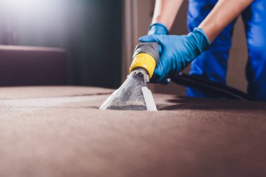 Kanepe kimyasal profesyonel çıkarma yöntemiyle Temizleme. Döşemeli mobilya. Erken bahar temizlik veya normal temizleyin. Kir kaldırmak ışık mavi koruyucu eldiven çalışan Kuru Temizleme
