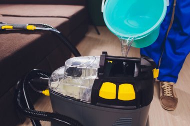 Kuru Temizleme için profesyonel ekipman. Kimya, çıkarıcı, renkli üniforma, iş giysisi erkekte içine dökülen su.