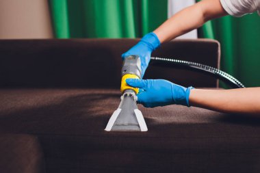 Kanepe kimyasal profesyonel çıkarma yöntemiyle Temizleme. Döşemeli mobilya. Erken bahar temizlik veya normal temizleyin. Kir mobilya kaldırma koruyucu eldiven çalışan Kuru Temizleme