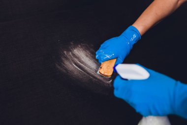 Kırpılmış görüntü. Temizlik kavramı. Erkek el koruyucu eldiven odada kanepe koltuk Temizleme