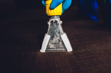Kanepe kimyasal profesyonel çıkarma yöntemiyle Temizleme. Döşemeli mobilya. Erken bahar temizlik veya normal temizleyin. Kir kaldırmak ışık mavi koruyucu eldiven çalışan Kuru Temizleme