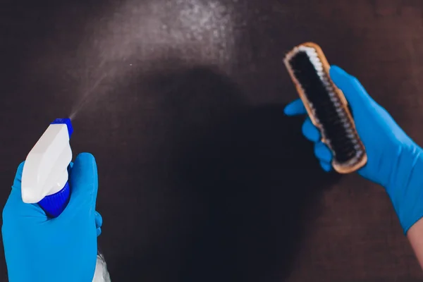 Bijgesneden afbeelding. Schoonmaak concept. Mannenhand in lichte blauwe beschermende handschoenen schoonmaak banklaag in de kamer. bovenaanzicht — Stockfoto