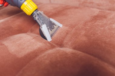 Kanepe kimyasal profesyonel çıkarma yöntemiyle Temizleme. Döşemeli mobilya. Erken bahar temizlik veya normal temizleyin. Kir kaldırmak ışık kırmızı koruyucu eldiven çalışan Kuru Temizleme