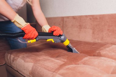 Kanepe kimyasal profesyonel çıkarma yöntemiyle Temizleme. Döşemeli mobilya. Erken bahar temizlik veya normal temizleyin. Kir kaldırmak ışık kırmızı koruyucu eldiven çalışan Kuru Temizleme