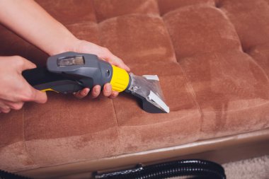 Kanepe kimyasal profesyonel çıkarma yöntemiyle Temizleme. Döşemeli mobilya. Erken bahar temizlik veya normal temizleyin. Kir kaldırmak ışık kırmızı koruyucu eldiven çalışan Kuru Temizleme