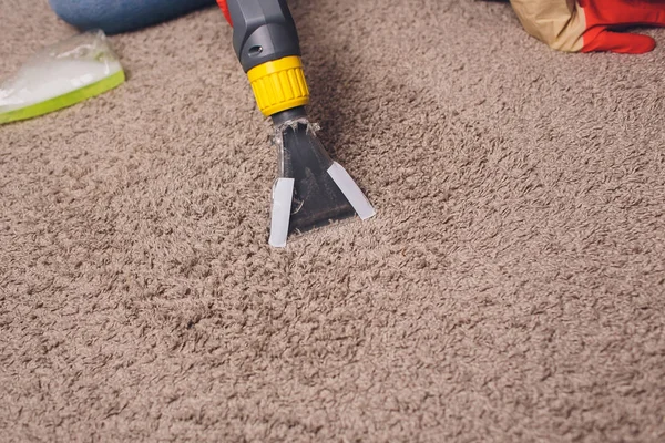 Woman removing dirt from carpet with vacuum cleaner in room. — Stock Photo, Image