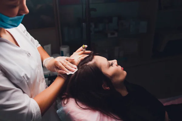 Beautiful woman getting injection for hair growth