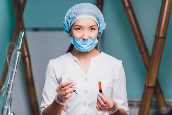Ritratto di una bella chimica donna che analizza una provetta di sangue in un plasma di laboratorio . — Foto Stock