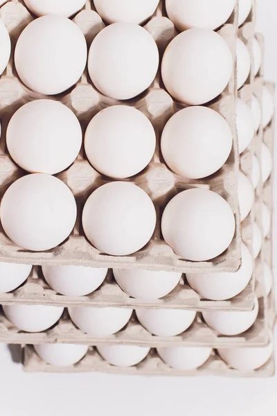 Ovos brancos de uma galinha em embalagem de cartão inofensiva em um contexto branco. 5 embalagens . — Fotografia de Stock