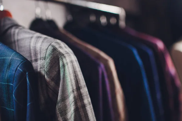 Chaquetas de pieza de trabajo en la percha de ropa en el estudio de sastrería . — Foto de Stock