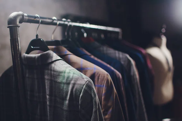 Chaquetas de pieza de trabajo en la percha de ropa en el estudio de sastrería . — Foto de Stock