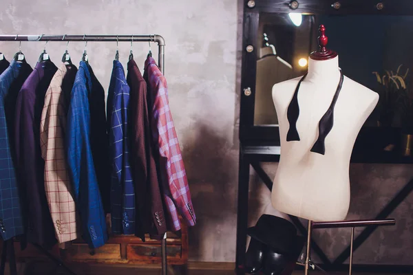 Chaquetas de pieza de trabajo en la percha de ropa en el estudio de sastrería . — Foto de Stock