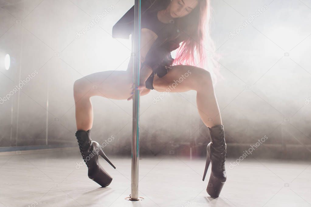 young striptease dancer moving in high heels shoes on stage in strip night club, Pole dancing