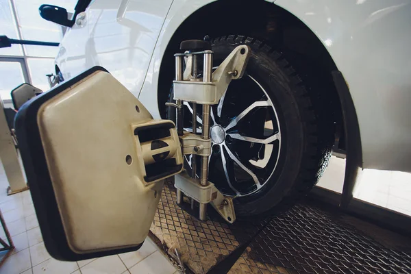 Una macchina sul bilanciere volante auto e calibrare con riflettore laser allegare su ogni pneumatico al centro di guida regolare in garage . — Foto Stock