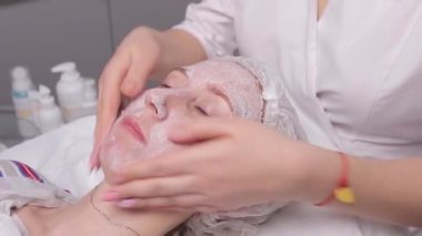 kozmetik maskesi spa salonu sahip güzel bir genç kadın. kızı kozmetik tedavi olacak.