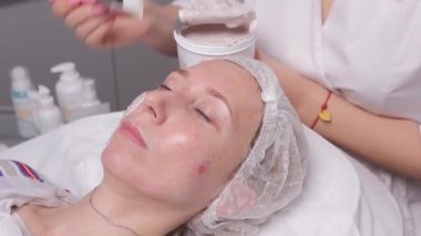 kozmetik maskesi spa salonu sahip güzel bir genç kadın. kızı kozmetik tedavi olacak.