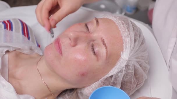 Bella giovane donna che ha una maschera cosmetica facciale al salone termale. Ragazza sta avendo un trattamento cosmetico . — Video Stock