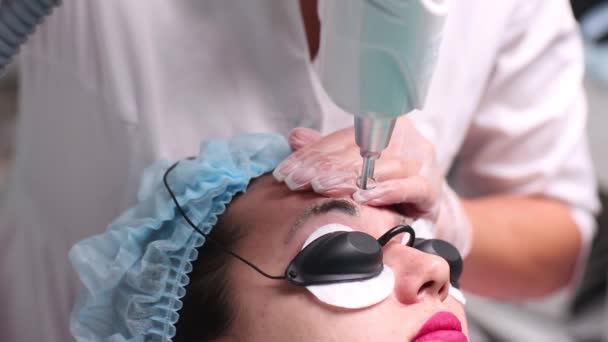 Rimozione laser di un trucco permanente su una faccia. Giovane donna di primo piano che riceve la correzione di un tatuaggio su procedura di sopraccigli. Correzione di imperfezioni naturali su una faccia . — Video Stock