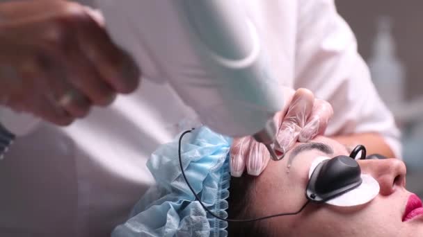 La desaparición láser del maquillaje permanente en la persona. Primeros planos mujer joven que recibe la corrección de un tatuaje en el procedimiento de las cejas. La corrección de las imperfecciones naturales en la persona . — Vídeos de Stock