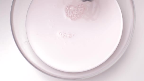 Milkshake aux baies mélangé dans un mélangeur avec fond blanc. Au ralenti. Vidéo recyclée . — Video