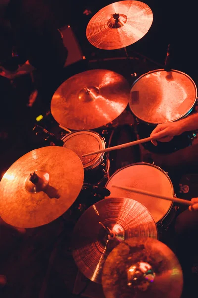 De mens bespeelt muziekpercussie-instrument met stokken close-up op een zwarte achtergrond, een muzikaal concept met de werkende drum, mooie verlichting op het podium. — Stockfoto