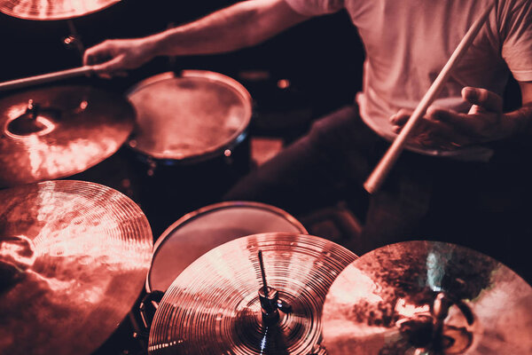 музыка, люди, музыкальные инструменты и развлекательная концепция - мужчина музыкант или барабанщик, играющий на ударных в студии на фоне праздничных огней
.