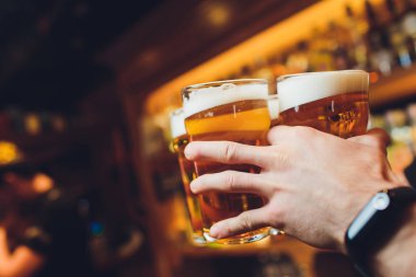 Barmen elleri bardağa bira dolduruyor..