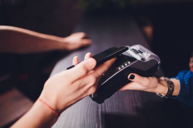 Memnun sakallı yakışıklı Cafe fatura için ödeme yaparken garson için kredi kartı veren kulaklık içerik.