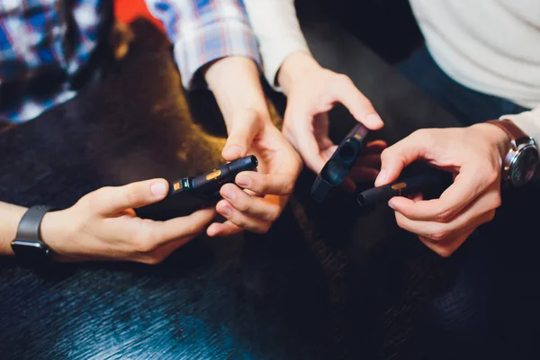 IQOS heat-not-burn tobacco product technology. Two Man holding e-cigarette in his hand before smoking. — Φωτογραφία Αρχείου