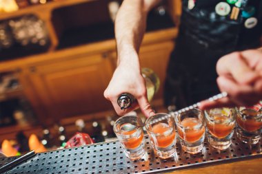 Barmen güçlü alkollü içecek bar, çekim küçük gözlük içine dökme.