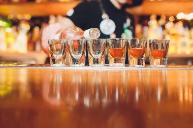 Barmen güçlü alkollü içecek bar, çekim küçük gözlük içine dökme.