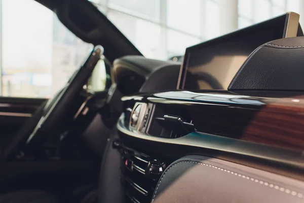 Dark luxury car Interior - steering wheel, shift lever and dashboard.