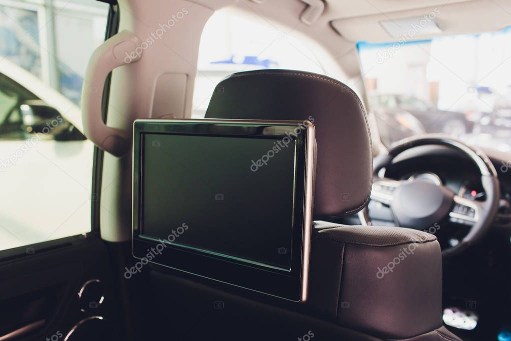 Car inside. Interior of prestige luxury modern car. Three TV displays for passenger with media control panel copy space and mock up.