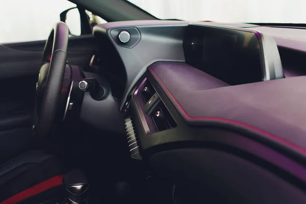 Dark luxury car Interior - steering wheel, shift lever and dashboard.