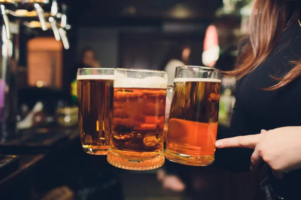 Femme main versant une pinte de bière derrière le bar . — Photo