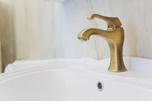 Білий інтер'єр ванної кімнати мийка, кран, клапани і багате прикрашене різьблене золоте і срібне дзеркало . — стокове фото