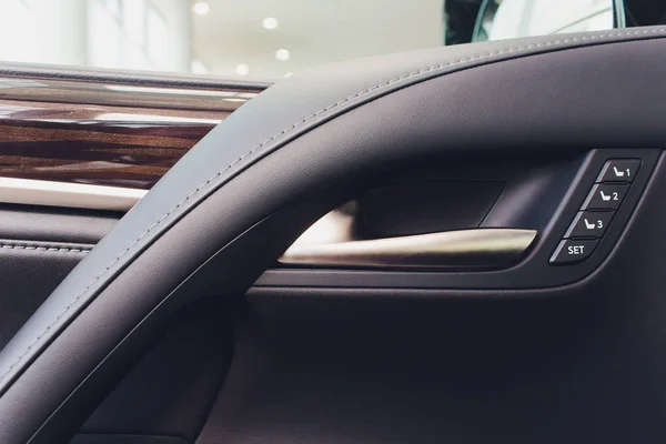 Auto drinnen. Interieur des modernen Prestigeautos. Klimaanlage, High-End-Lautsprecher, Sitzspeicher, Türhebel-Seitenspiegel. weißes Cockpit mit Holz-Metall-Dekoration blaues Umgebungslicht. — Stockfoto