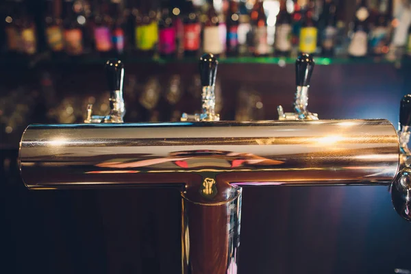 The bar counter with bottles and apparatus for dispensing beer. Apparatus for dispensing beer at the bar. Pub. The bar in the restaurant. Apparatus for dispensing beer in a restaurant. — Stock Photo, Image