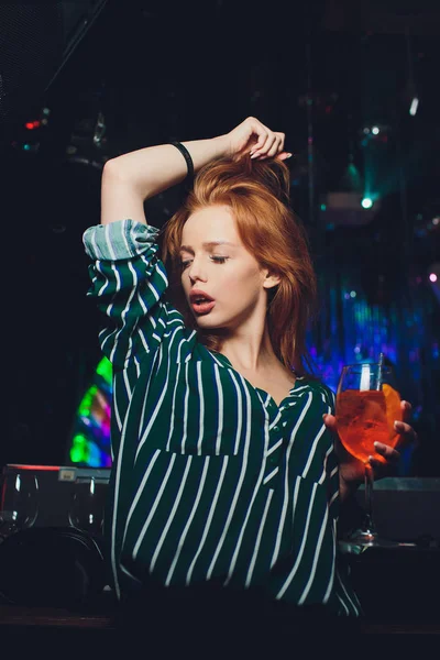 Mujer feliz bailando en el club nocturno con bebidas en la mano . — Foto de Stock