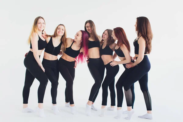 Fitness, exercice d'étirement, groupe de deux jolies femmes mûres souriantes qui travaillent dans un club de sport, faisant une posture d'angle latéral étendu, pose utthita parshvakonasana en classe, pleine longueur . — Photo