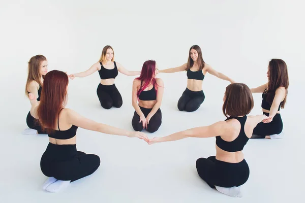 Fitness, stretching praxis, grupp av två attraktiva glada leende passar mogna kvinnor som arbetar i idrotts förening, gör förlängd sido vinkel hållning, utthita parshvakonasana pose i klassen, full längd. — Stockfoto