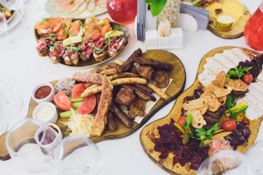 Aile Barbekü partisi için piknik masa üzerinde beyaz tabakta sebze ile çeşitli lezzetli ızgara et.