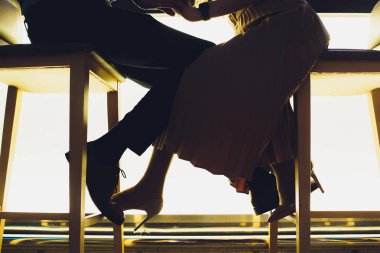 Bir restoranda aşk sarılmaya düşen çift bacaklar siluet.