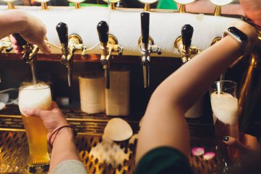 Barmen bardaki bardağa taze bira dolduruyor..