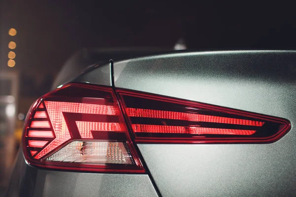 De achterlichten van een moderne prestigieuze auto vanuit een nauwe hoek, de autoshow. — Stockfoto